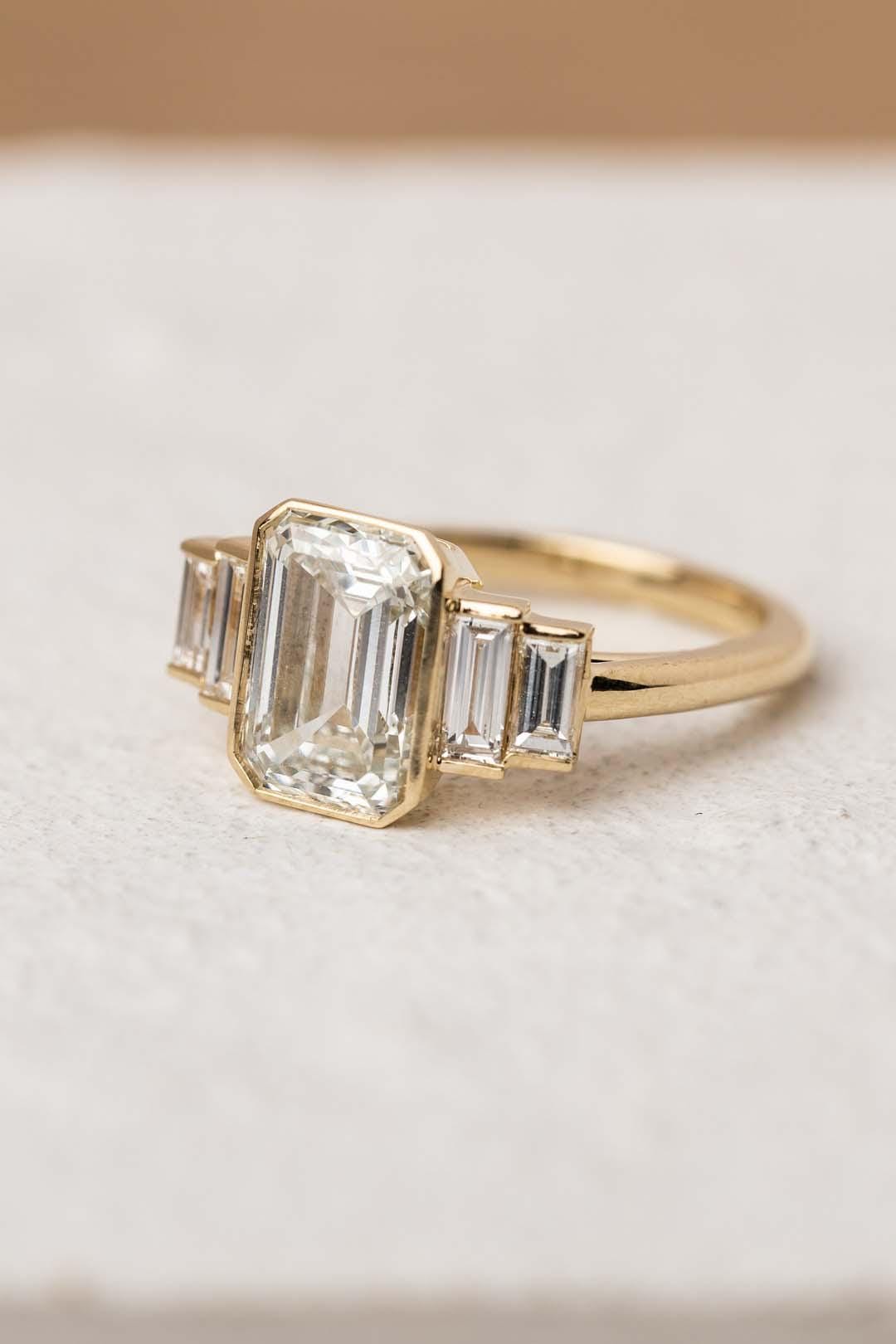 Vintage Emerald Cut Moissanite Five Stone Ring: 14K White Gold Bezel Set